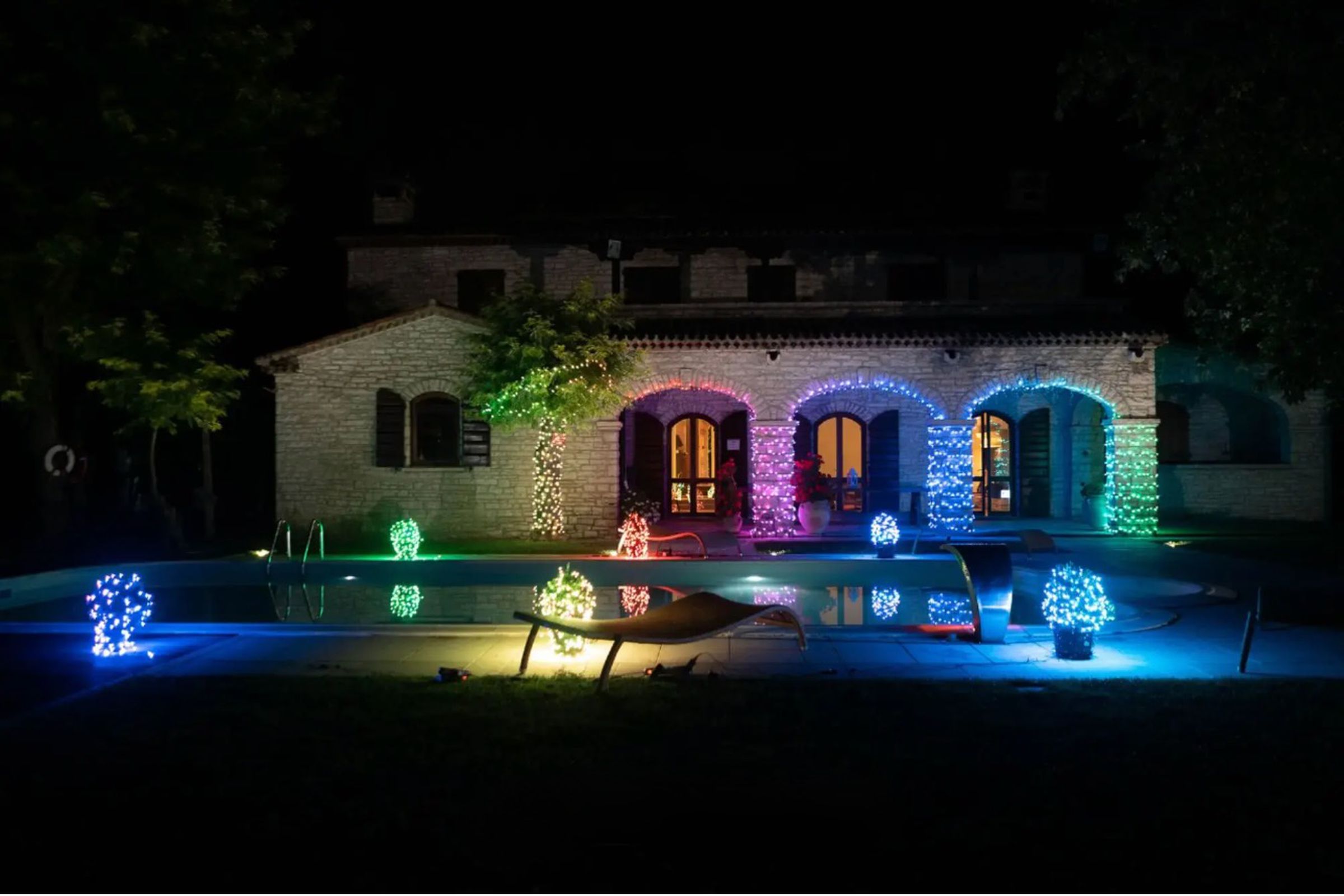 House at night lit up by multicolored lights