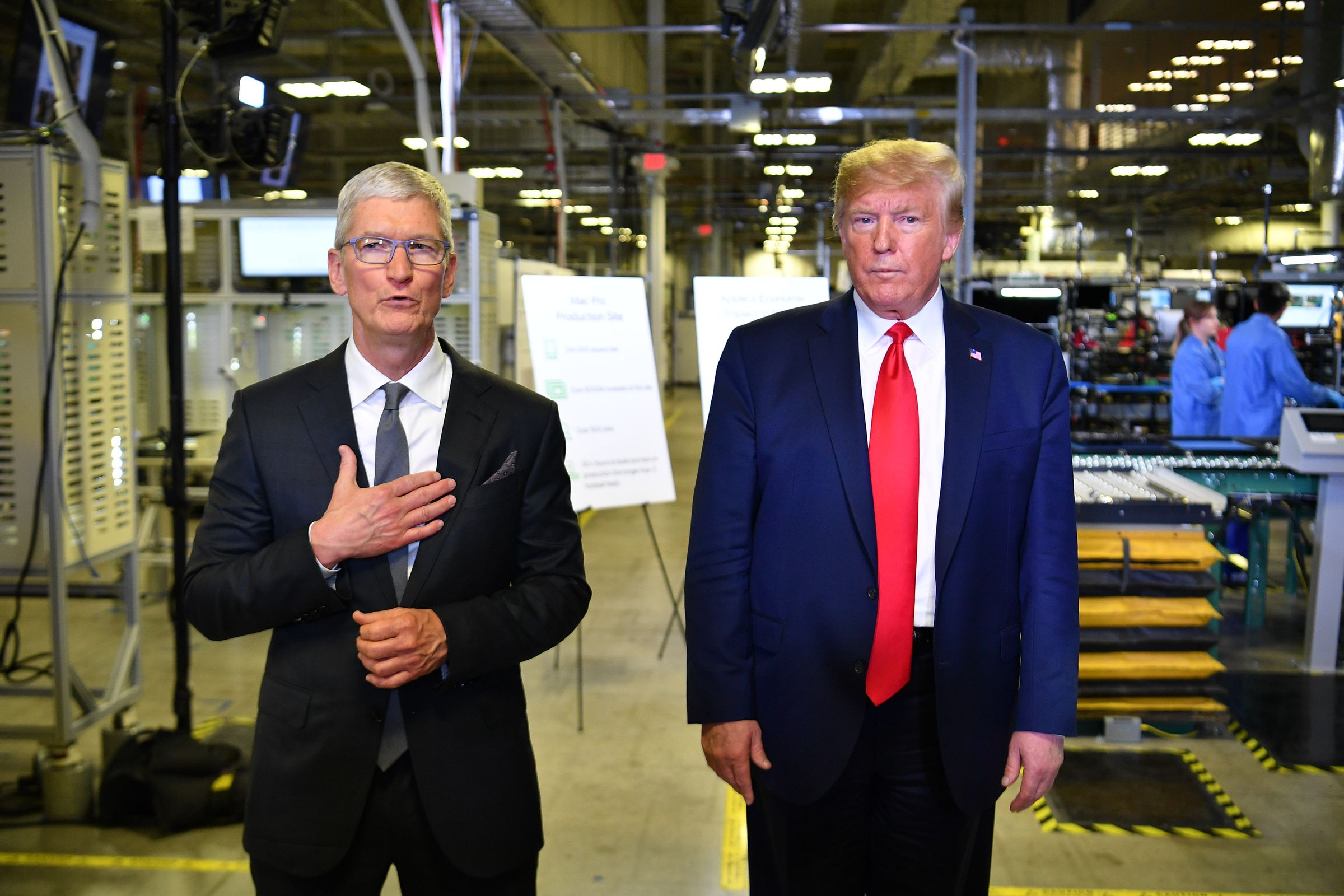 US President Donald Trump (r) and Apple CEO Tim Cook speak to the press during a tour of the Flextronics computer manufacturing facility where Apple’s Mac Pros are assembled in Austin, Texas, on November 20, 2019.