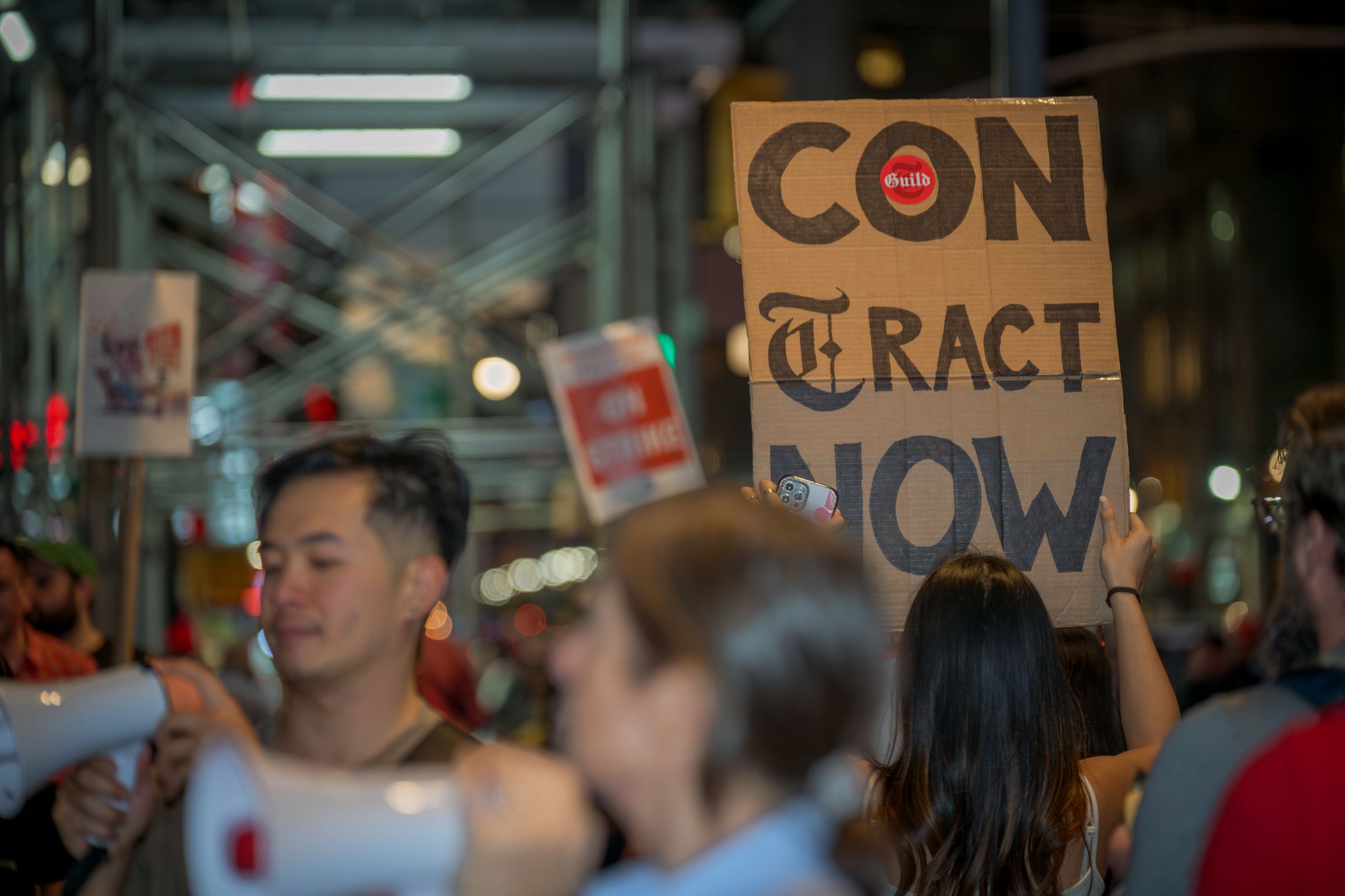 Participant seen holding a sign at the picket line outside...