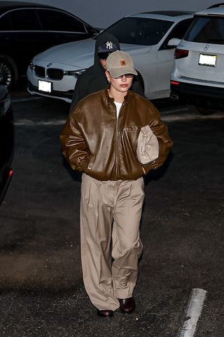 Hailey Bieber wearing a brown leather bomber jacket