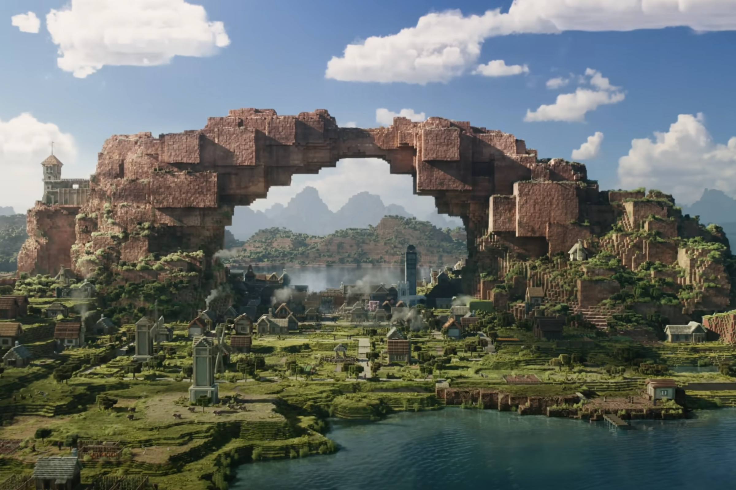 Still image from A Minecraft Movie showing a large stone archway looming over a village below.