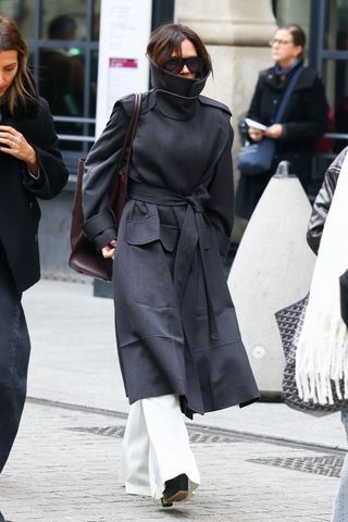 Victoria Beckham wears a funnel neck coat.