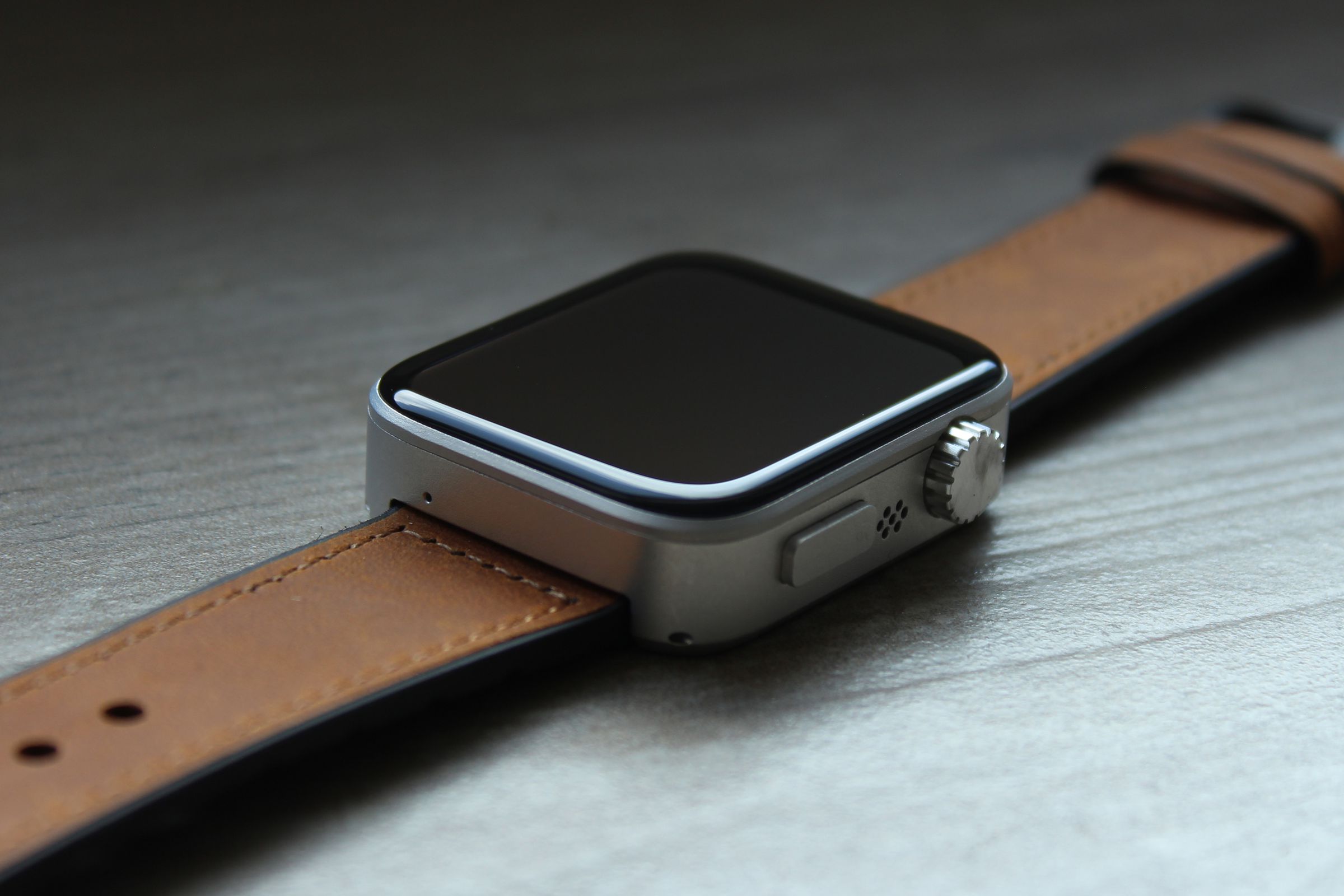 A close-up of the Pocuter Spectra smartwatch with a brown leather strap attached.