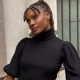 Camri Hewie poses while wearing a puff-sleeve sweater