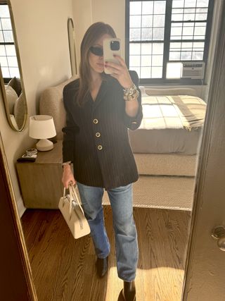 Nikki Chwatt carrying her oat Mercer Bag while wearing a vintage blazer, jeans, and black shoes.