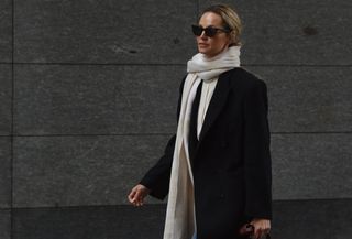 Anouk wears a white cashmere scarf and black jacket.