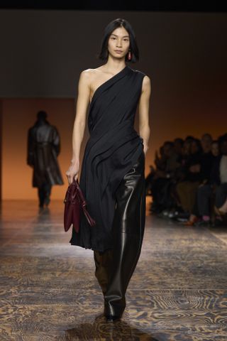 Barrel leg leather trousers and one shoulder black top Bottega Veneta fall winter 2024.