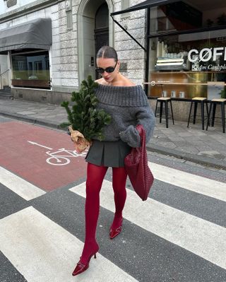 Fashion influencer  @lara_bsmnn wearing a chic winter outfit styled with 2024/2025's burgundy tights trend.