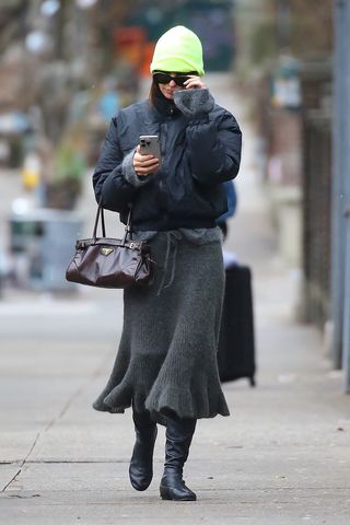 Emily Ratajkowski wearing a puffer and sweater skirt in NYC