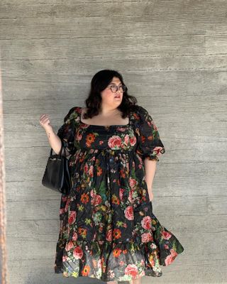 A Nordstrom stylist wearing a floral print midi dress.