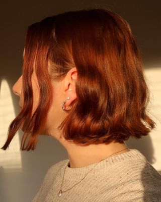 Woman with several gold piercings in her ear.