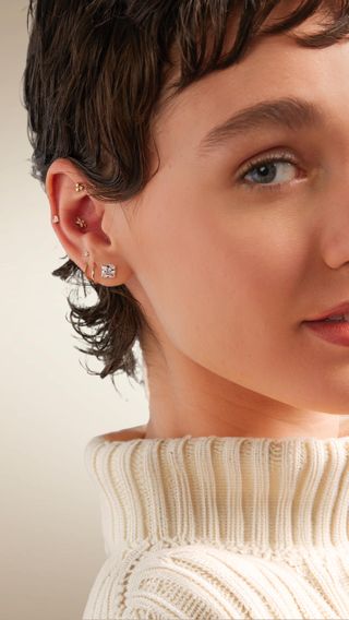 Woman with several gold piercings in her ear.