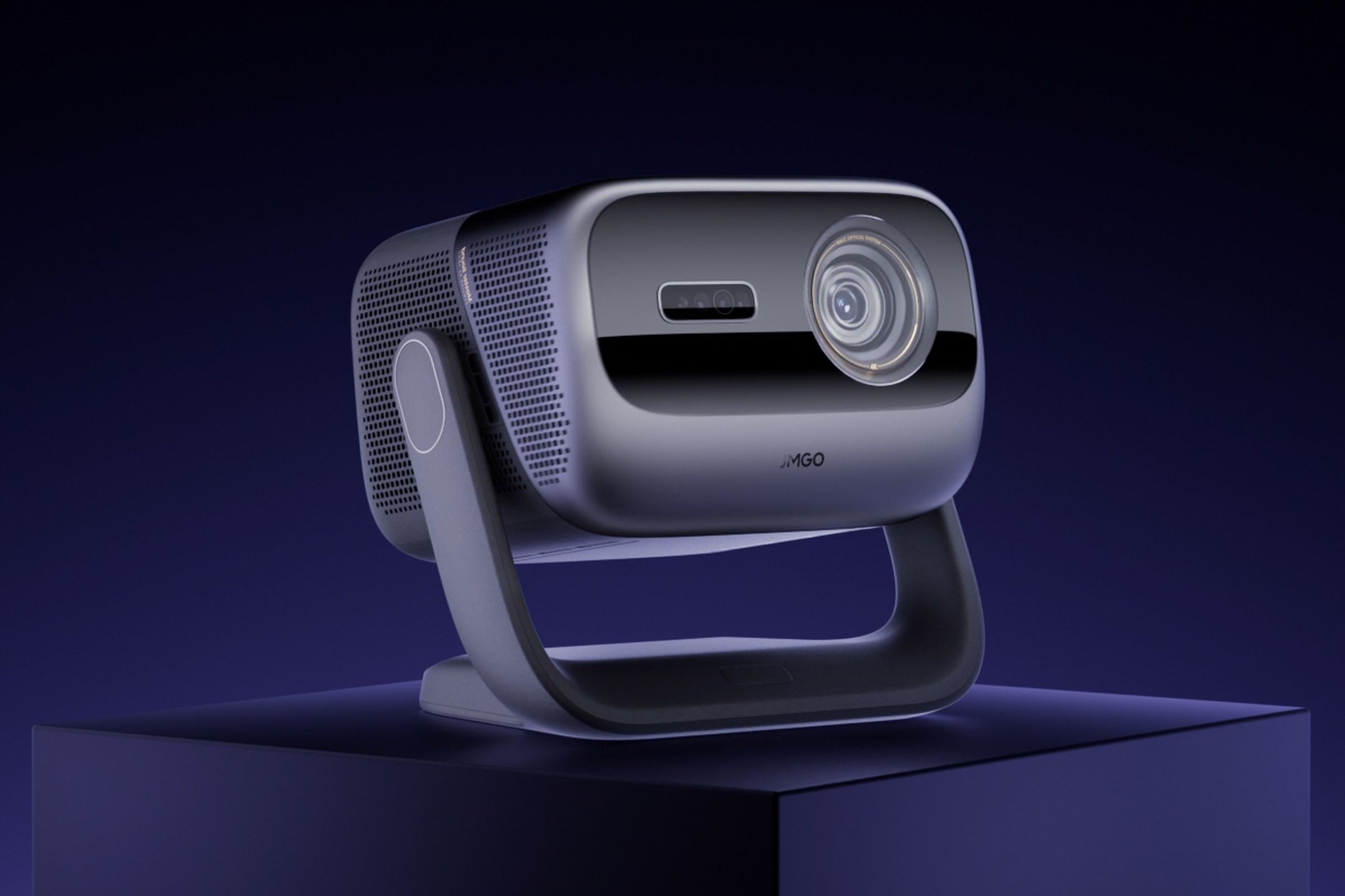 The JMGO N3 Ultra Max projector sitting on a pedestal against a purple backdrop.