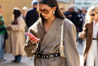 woman in blazer looking at her phone