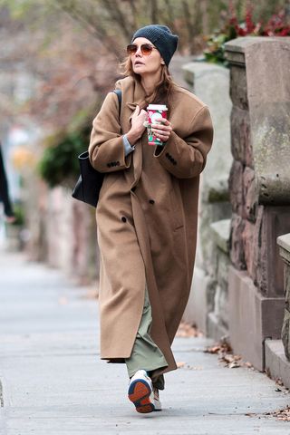 Katie Holmes wearing a camel coat and olive green pants